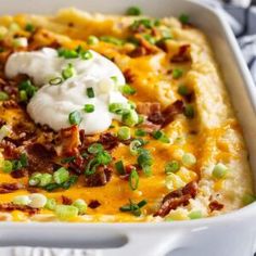 a casserole dish topped with bacon, sour cream and green onions