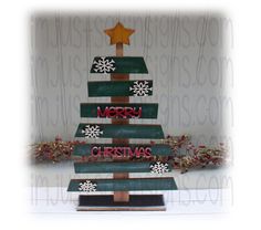 a christmas tree made out of wooden planks with snowflakes on top and merry lettering