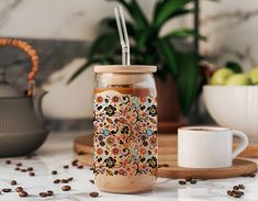 a jar filled with liquid sitting on top of a table next to some coffee beans