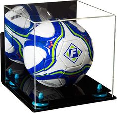 a soccer ball in a clear case with blue and green accents on the bottom shelf