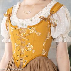 Elevate your Renaissance Faire costume with our exquisite Golden Yellow Floral Renaissance Corset, which features a radiant yellow corset with linen fabric adorned white floral embroidery. This handmade yellow corset bodice blends historic charm and modern style for a unique, regal look, perfect for Renaissance fairs, hobbit picnics, and strolls through wildflowers. Yellow Corset, Ren Faire Outfits, White Floral Embroidery, Soft Fashion, Amazing Dresses, Corset Bodice, Yellow Outfit, Medieval Dress, Corsets And Bustiers