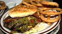 a hamburger and some onion rings on a plate