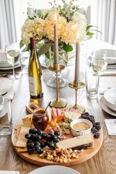 a wooden table topped with lots of food and wine