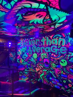 an indoor area with neon lights and graffiti on the walls, painted in bright colors