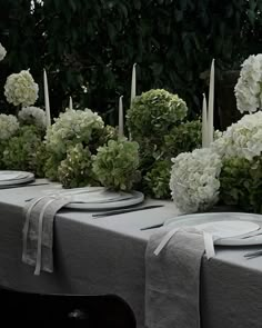 the table is set with white flowers and candles