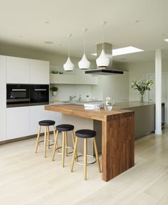 a kitchen with three stools and an island in front of the stove top oven