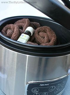 an open crock pot filled with rolled up brown towels and essential oils in it