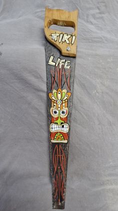 an old skateboard with some designs on it's back end and wooden handle