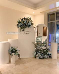 the entrance to a boutique with flowers and mirrors on it's walls, in front of an arched doorway