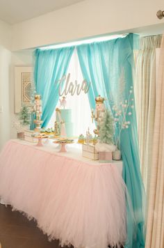 a pink and blue dessert table set up for a princess birthday party with gold decorations