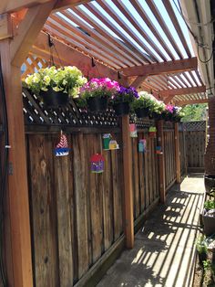 a wooden fence with potted plants hanging from it's sides and attached to the side