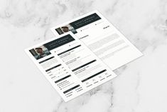 two resume templates sitting on top of a marble surface with black and white accents