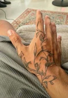 a man's hand with tattoos on it