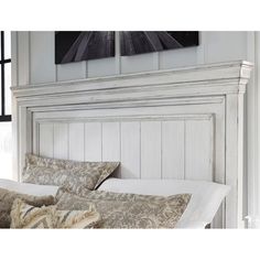 the headboard and foot board of a bed in a room with white paint on it