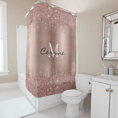 a pink shower curtain with the word me on it in front of a white toilet and sink