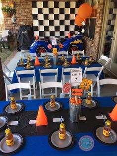 an image of a table set up for a race car themed birthday party with cars and cones on it