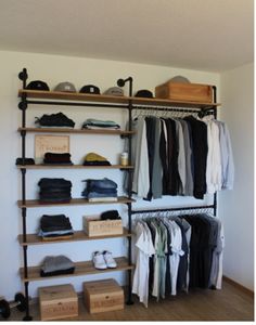 an organized closet with clothes, shoes and boxes on the shelves in front of it