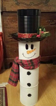 a snowman made out of paper plates sitting on top of a wooden table