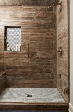 a walk in shower sitting next to a wooden wall and tiled floor with a window