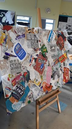 an easel is covered with various pieces of paper and stickers in the shape of a heart