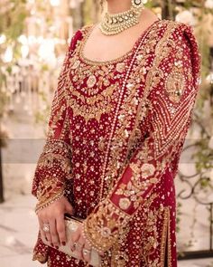 a woman in a red and gold bridal outfit