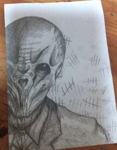 a pencil drawing of an alien head on paper