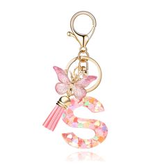 a pink key chain with a butterfly on it and a tassel hanging from the front