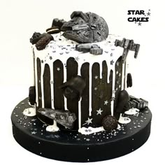 a star wars themed cake with white frosting and black icing on a plate