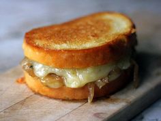 a grilled cheese sandwich sitting on top of a cutting board