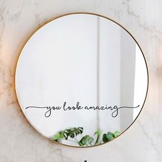 a round mirror with the word, smile happily written in cursive writing on it