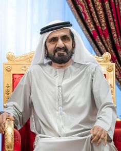 a man sitting in a chair wearing a white outfit