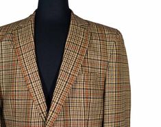 This Chiragh Apparel blazer is an elegant upgrade on dapper tailoring and features rich shades in a sumptuous fabric for elegant opulence. Fashioned from premium quality wool, this plaid check blazer features full lining in Japanese silk, a notch lapel, two-button closure and a single-vented back. A left chest pocket and three flap pockets appoint the front while the inside has two (2) pockets on the left and one (1) pocket on the right. A flash of contrast piping is added to the jacket lining i Tailored Fall Sport Coat For Semi-formal Occasions, Tailored Semi-formal Sport Coat For Fall, Tailored Elegant Sport Coat For Fall, Bespoke Tailored Suits For Fall, Bespoke Tailored Fall Suits, Fall Formal Sport Coat With Hidden Button Closure, Formal Fall Sport Coat With Hidden Buttons, Bespoke Notch Lapel Suits For Fall, Formal Fall Tweed Jacket With Notch Lapel