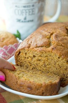 a close up of a loaf of bread on a plate with a cup in the background