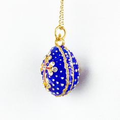 "Enameled and 24 K gold plated over solid sterling silver, royal blue 3 D egg pendant with the cross in front, and the Moravian star at the opposite side, designed and created in our NJ shop in the tradition of Faberge jewelry. The egg is 0.8\" (20 mm ), not including a tiny cross at the top, 1.0\" ( 28 mm ) with a ring for a chain. It comes ready to wear with 18\" sterling silver gold plated chain, and in a gift box. If you feel that you need a longer chain, please, contact us, or request it du Blue Enamel Locket Jewelry, Blue Enamel Oval Pendant Jewelry, Blue Oval Enamel Necklace, Cross Pendant Locket Jewelry Gift, Cross Pendant Locket Jewelry For Gift, Gift Cross Pendant Locket Jewelry, Blue Gold Plated Jewelry With Charms, Blue Gold-plated Jewelry With Charms, Oval Enamel Jewelry For Gift