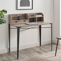 a desk with a laptop and some books on it next to a potted plant