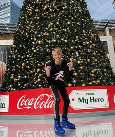 a boy skates in front of a christmas tree at the coca - cola center