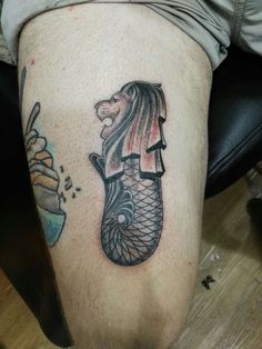 a man's leg with a tattoo of a mermaid and fish on the side