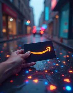 a person holding up a card with an amazon logo on it in the middle of a street