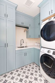 a washer and dryer in a kitchen with blue cabinets