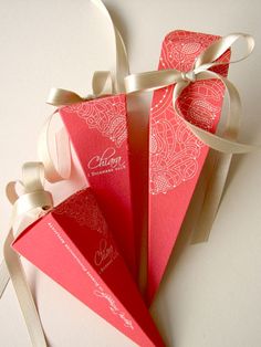 three red envelopes with white ribbons tied around them