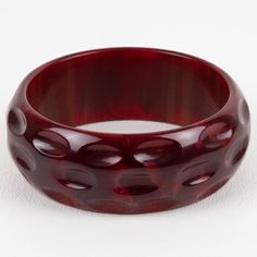 This is part of Chairish’s Costume Jewelry assortment.  This is a stunning crimson-red marble Bakelite bracelet bangle. It features a chunky domed shape with geometric and deeply carved designs. The color is an intense red marble tone with cloudy swirling.  Measurements: Inside across is 2.50 in diameter (6.3 cm) - outside across is 3 in diameter (7.7 cm) - width is 1.07 in (2.7 cm) - The inner circumference of the bracelet is 7.79 in (19.78 cm).  Please see the measurements noted above in the d Luxury Red Bangle, Modern Red Bangle Bracelet, Modern Red Bangle Bracelets, Elegant Bakelite Bangle As Gift, Elegant Bakelite Bangle As A Gift, Elegant Red Round Cuff Bracelet, Elegant Bakelite Bracelets As A Gift, Elegant Bakelite Bracelets For Gift, Bakelite Bracelets