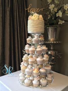 a wedding cake and cupcakes on a table