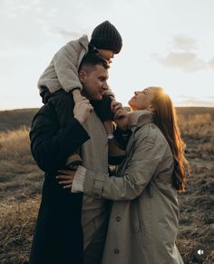 a man and woman standing in a field with the sun shining down on their heads