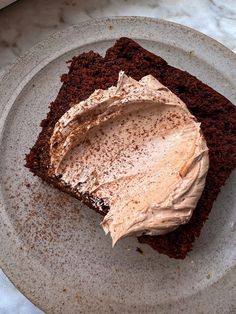 a piece of chocolate cake with frosting on a plate