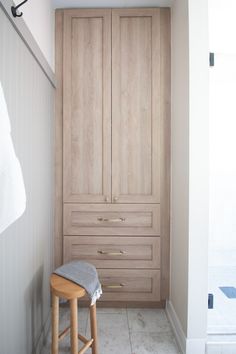 a bathroom with wooden cabinets and stools