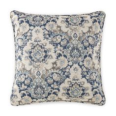 a blue and white pillow with an ornate pattern on the front, sitting on a white background