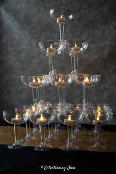 there are many wine glasses that have candles in them on top of each glass holder