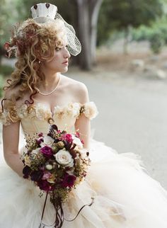 a woman in a wedding dress holding a bridal bouquet and wearing a tiara