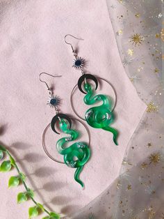 Green and silver celestial snake earrings. The earrings are big and will surely catch people's eyes but luckily they weigh next to nothing, only about 2 grams per earring! The snake is made out of resin, with silver flakes and alcohol ink. All the details and hooks are hypoallergenic and silverplated.  The whole earring with hook is 115 mm. Without the hook its 85x40 mm big.  If you don't want hooks you can choose rings or clipons in the menu. Both options are also silverplated and nickelfree. T Witch Accessories, Witch Earrings, Snake Earrings, Snake Jewelry, Creative Process, Resin Jewelry, Boho Earrings, Alcohol Ink, Statement Earrings