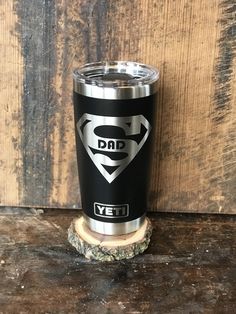 a black and silver yeti cup sitting on top of a wooden table